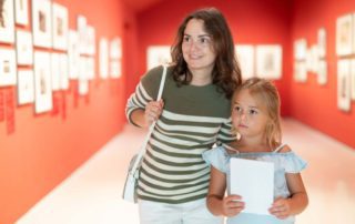 A woman and a child looking at Texas Hill Country art.