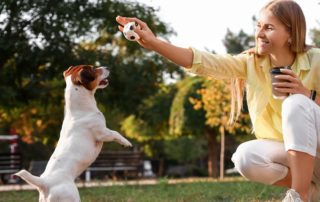 A woman playing with her dog in a New Braunfels dog park.